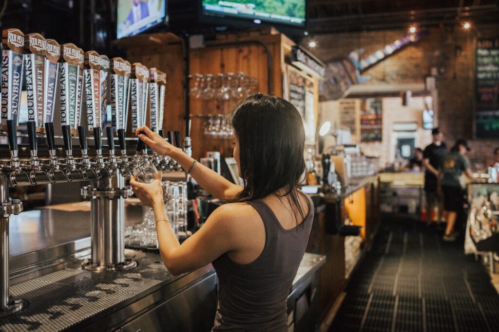 Bartender pouring draught beer in a busy venue