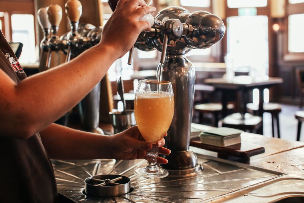 Draught beer being poured at a bar counter