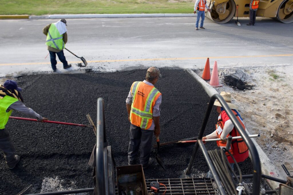 Road crew in hi-vis laying asphalt